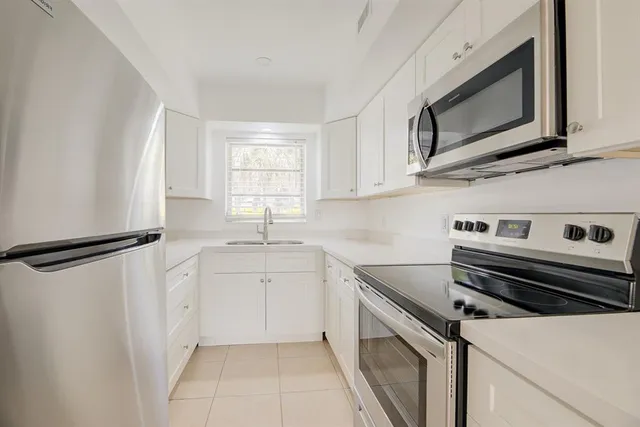 a kitchen with stainless steel appliances a refrigerator sink and microwave