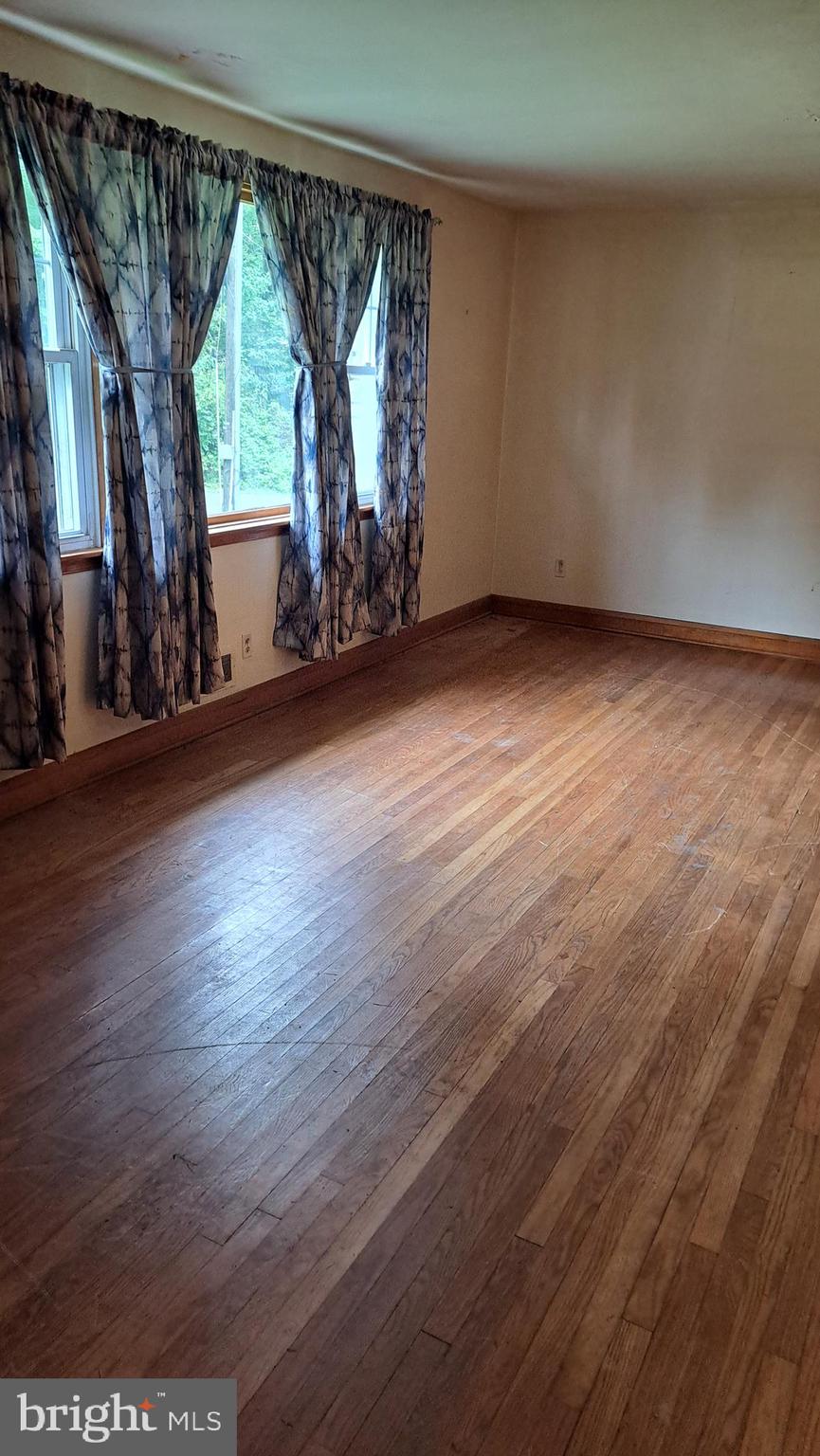 4401 East Joppa Road Perry Hall, MD 21236 - Photo 6 of 32 an empty room with wooden floor and windows