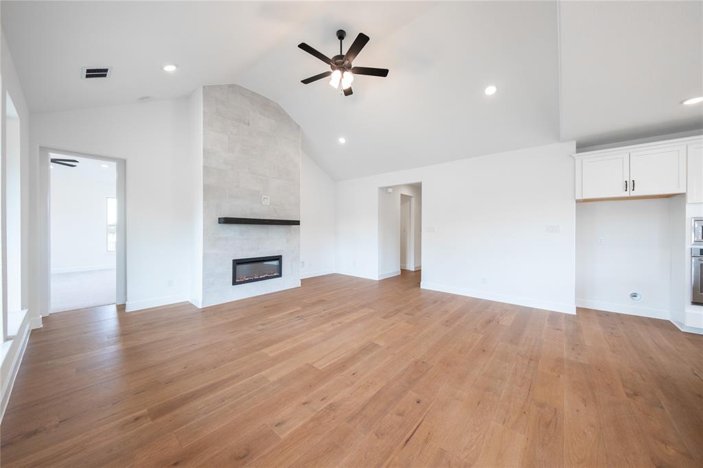 2715 Triumph Court Heath, TX 75126 - Photo 7 of 30 a view of empty room with wooden floor and kitchen view