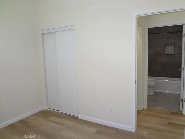 an empty room with wooden floor and a window