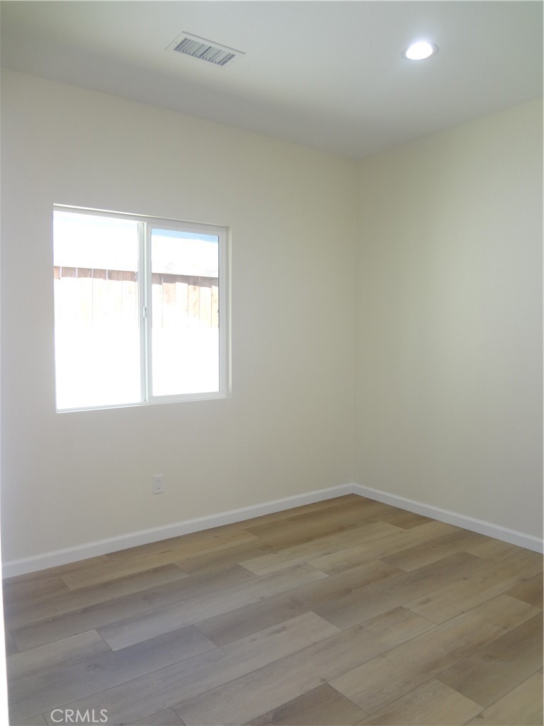 1717 2nd Street San Fernando, CA 91340 - Photo 13 of 18 an empty room with wooden floor and a window