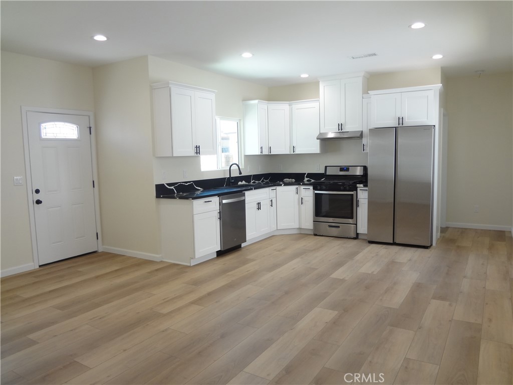 1717 2nd Street San Fernando, CA 91340 - Photo 2 of 18 a kitchen with granite countertop a stove and a refrigerator