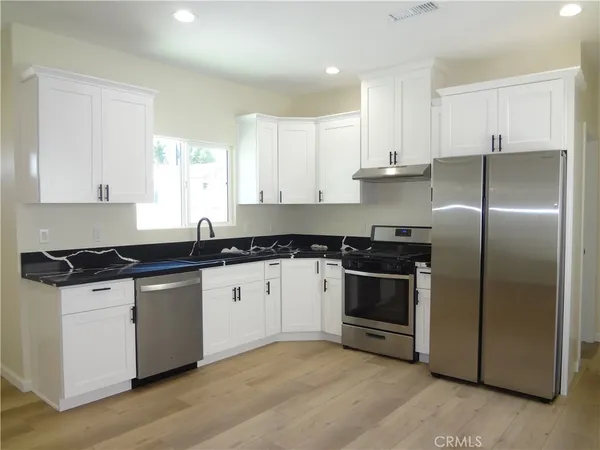 a kitchen with granite countertop a refrigerator and a sink