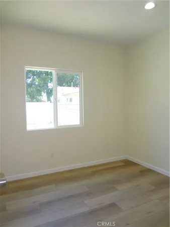 a view of a small space with wooden floor and a window