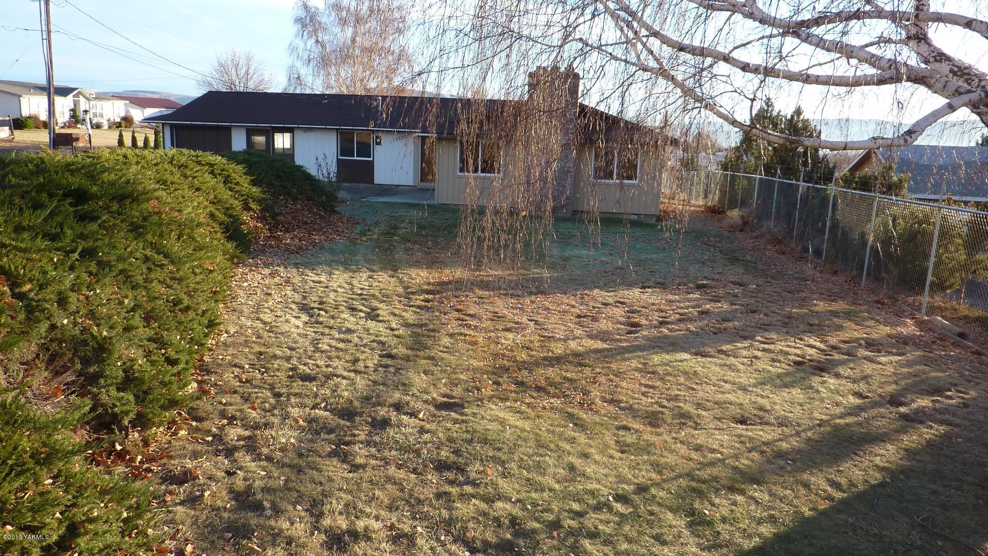 10030 Mieras Road Yakima, WA 98901 - Photo 2 of 23 a backyard of a house with lots of green space