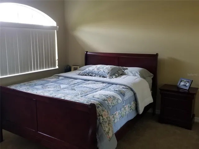 a bed sitting in a bedroom next to a window
