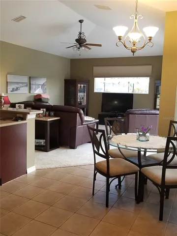 a kitchen with stainless steel appliances granite countertop a sink dishwasher a dining table and chairs with wooden floor