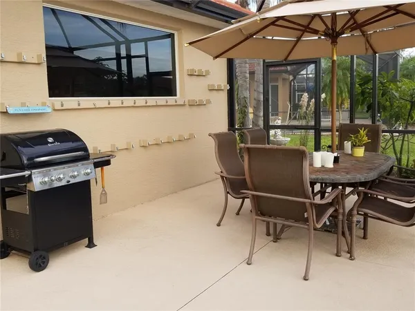 a view of a patio with a table and chairs under an umbrella