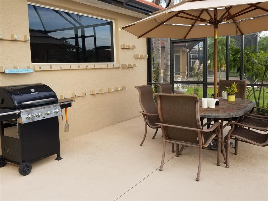 6380 Rookery Circle Bradenton, FL 34203 - Photo 17 of 22 a view of a patio with a table and chairs under an umbrella