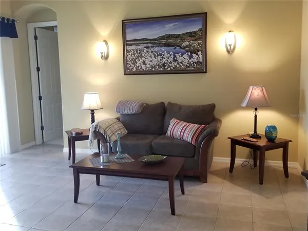 a living room with furniture a lamp and a window