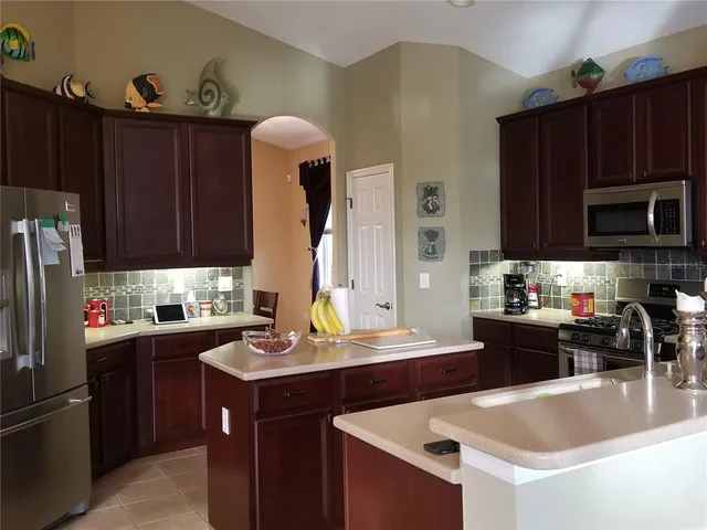 a kitchen with a sink a stove and wooden cabinets