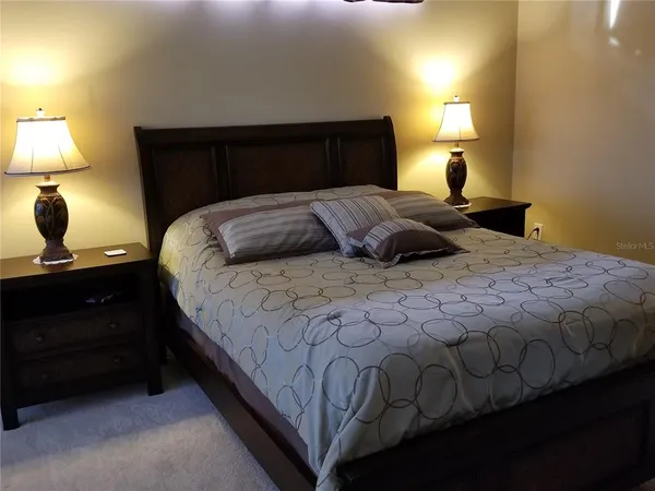 a bedroom with a bed and a lamp