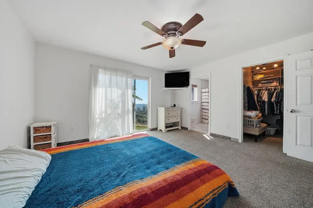 a living room with furniture a ceiling fan and a window