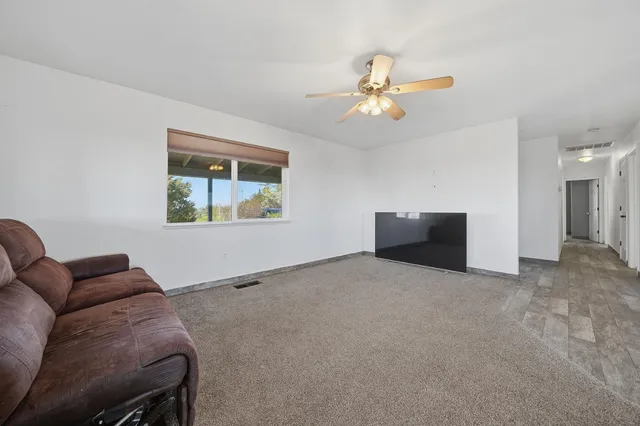 a view of a dining room with furniture and a chandelier fan