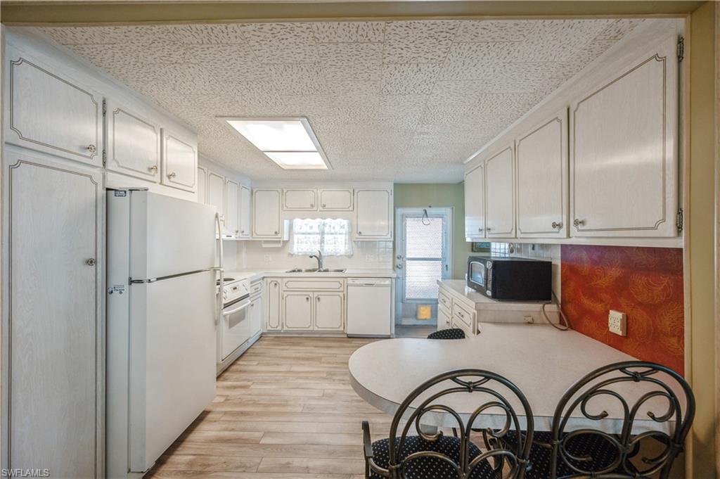 32 Monaco Terrace Naples, FL 34112 - Photo 6 of 19 a kitchen with a refrigerator and white cabinets