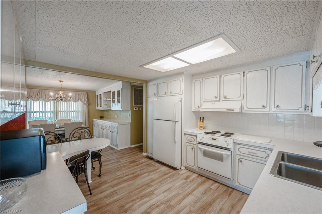 32 Monaco Terrace Naples, FL 34112 - Photo 7 of 19 a kitchen with white cabinets and appliances