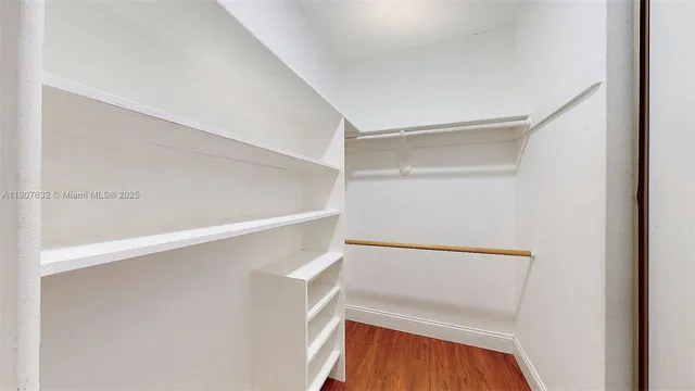 a view of walk in closet with wooden floor