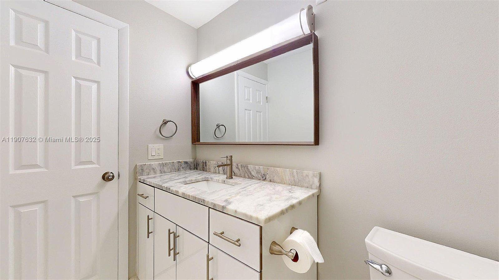 11339 Southwest 71st Street, Unit 11339 Miami, FL 33173 - Photo 24 of 28 a bathroom with a sink toilet and mirror