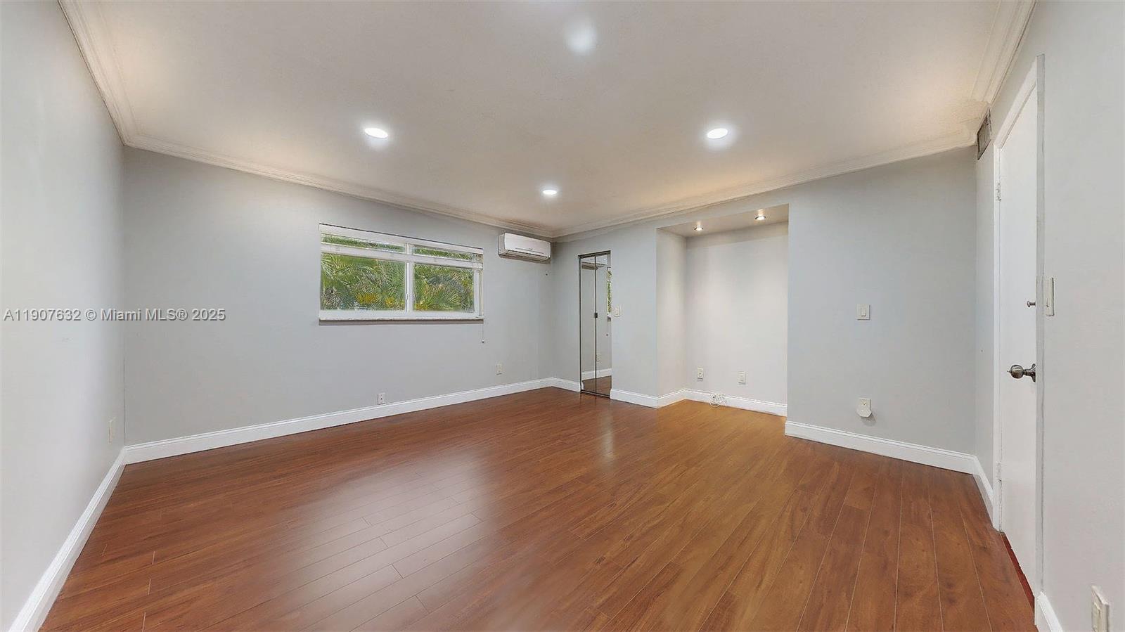 11339 Southwest 71st Street, Unit 11339 Miami, FL 33173 - Photo 6 of 28 an empty room with wooden floor and windows