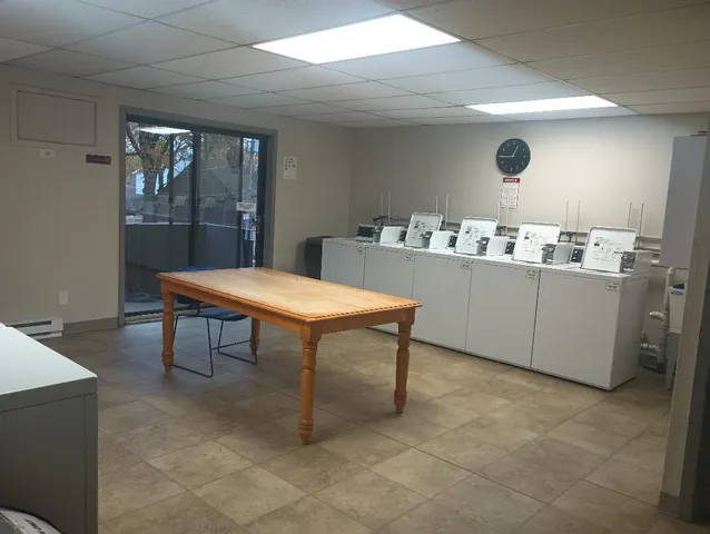 a room with table chairs and wooden floor