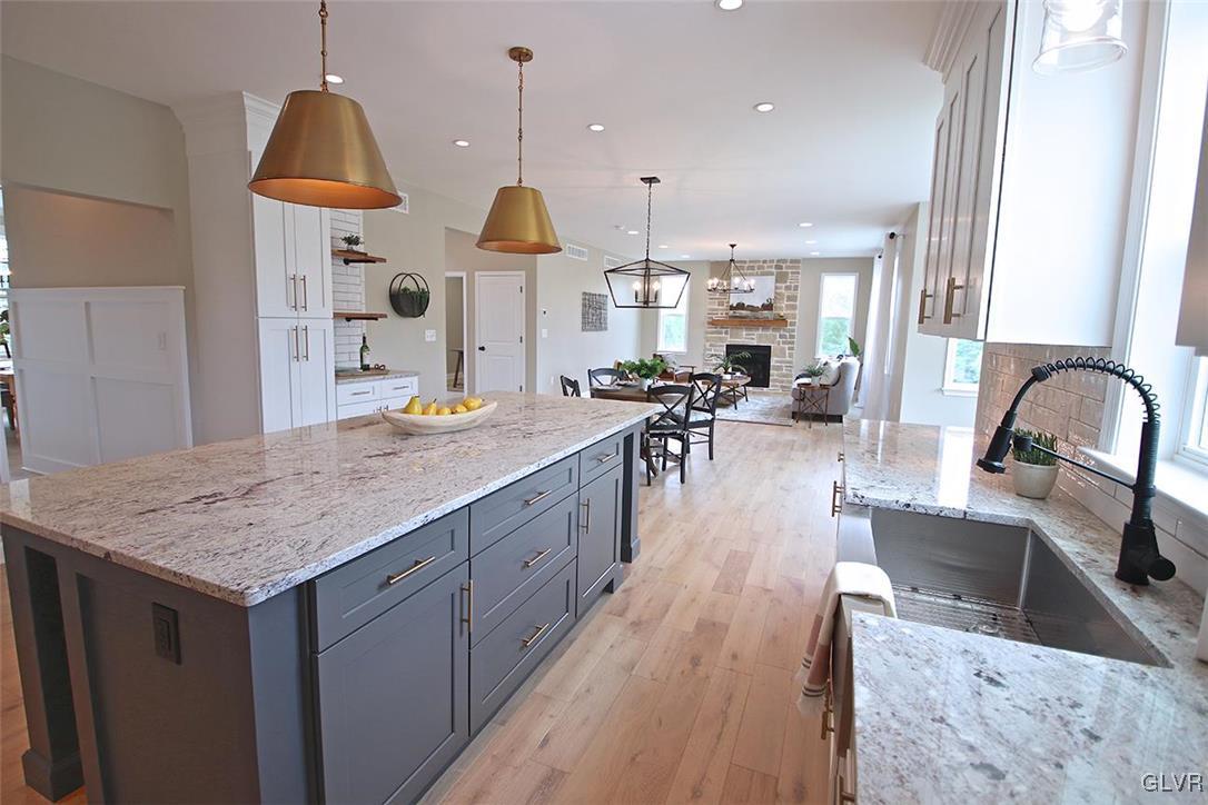 650 Clearfield Road Nazareth, PA 18064 - Photo 8 of 50 a kitchen with stainless steel appliances granite countertop a kitchen island a stove a sink a oven and a dining table with wooden floor