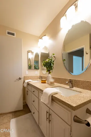 a bathroom with a granite countertop sink and a mirror