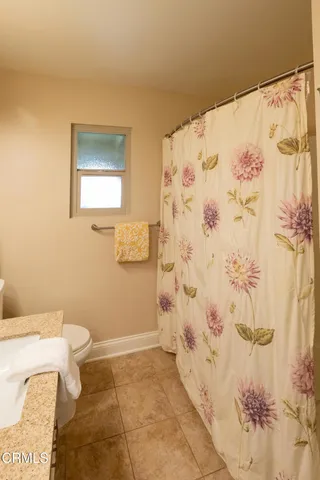 a bathroom with a toilet and a shower curtain