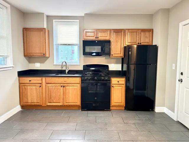 a kitchen with granite countertop a refrigerator and a stove