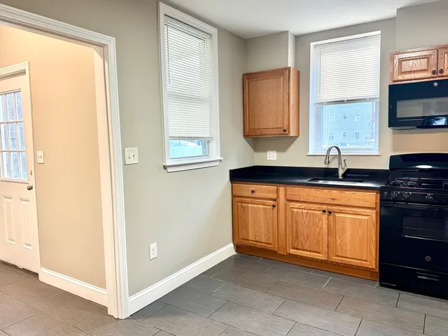 a kitchen with granite countertop cabinets and window