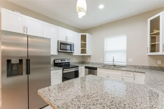 a kitchen with a refrigerator a sink a stove and cabinets