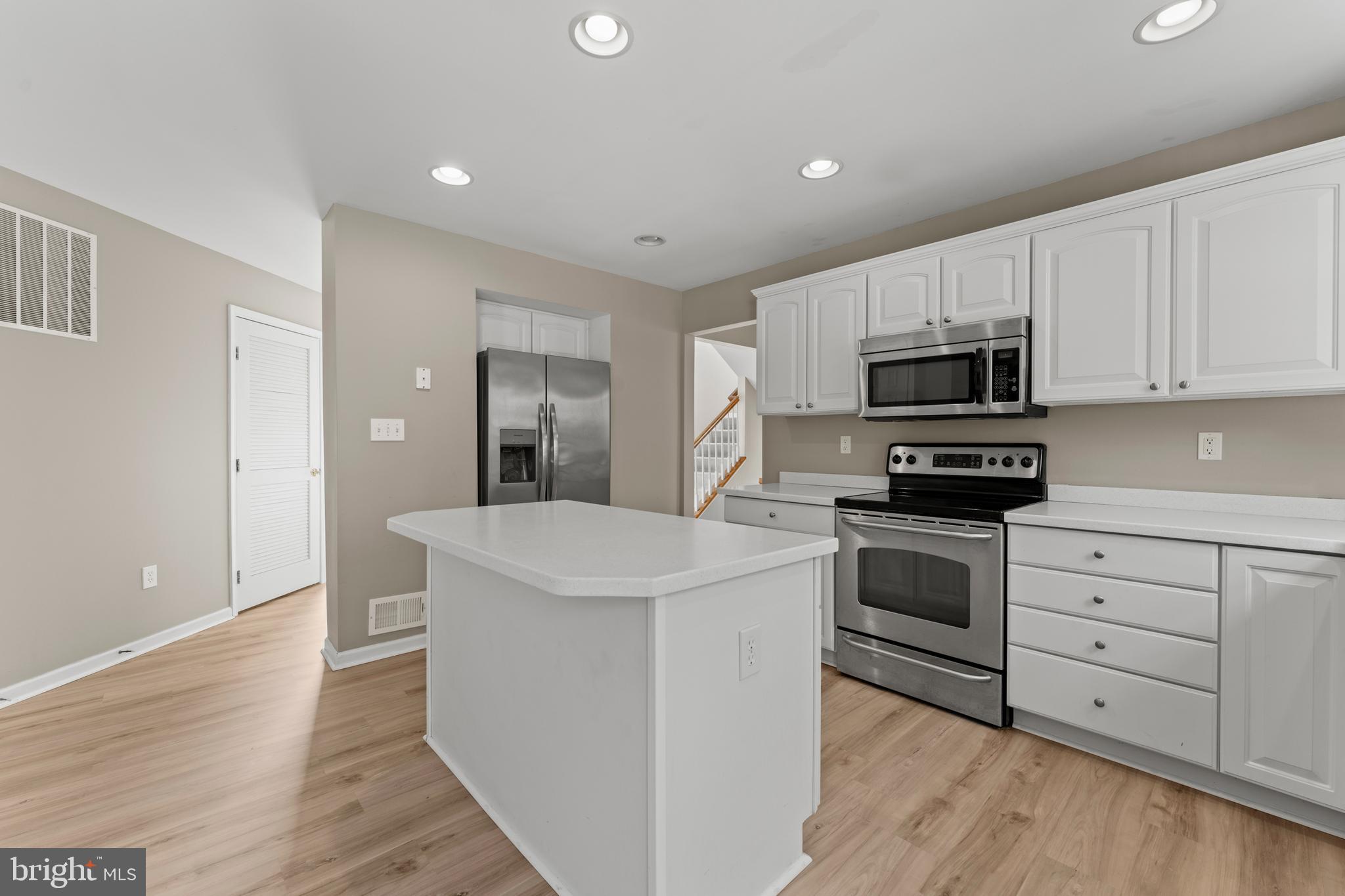 7756 Seneca Ridge Drive York, PA 17403 - Photo 19 of 50 a kitchen with stainless steel appliances white cabinets a sink a stove a microwave and island