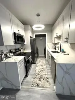 a kitchen with stainless steel appliances kitchen island granite countertop a sink stove and cabinets