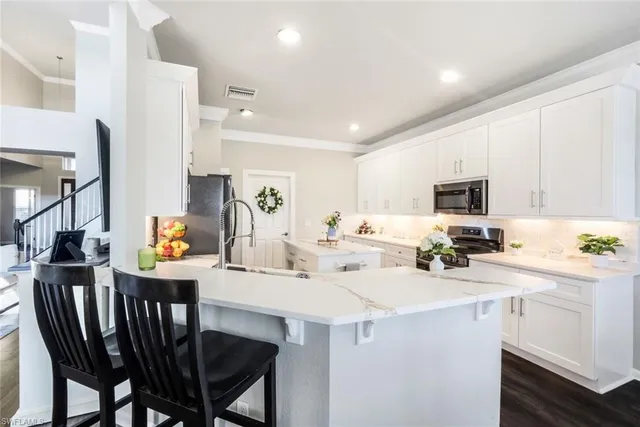 a kitchen with a table chairs microwave and cabinets