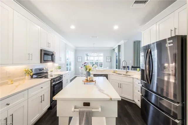 a kitchen with white cabinets and stainless steel appliances