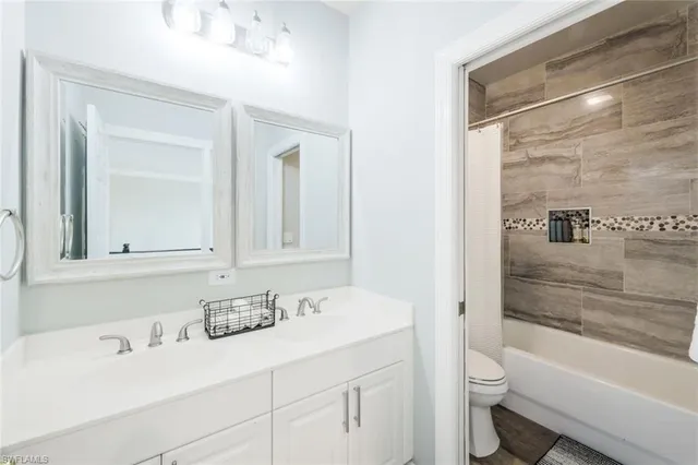 a bathroom with a bathtub shower sink vanity and toilet