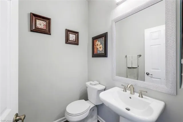a bathroom with a toilet a sink and mirror
