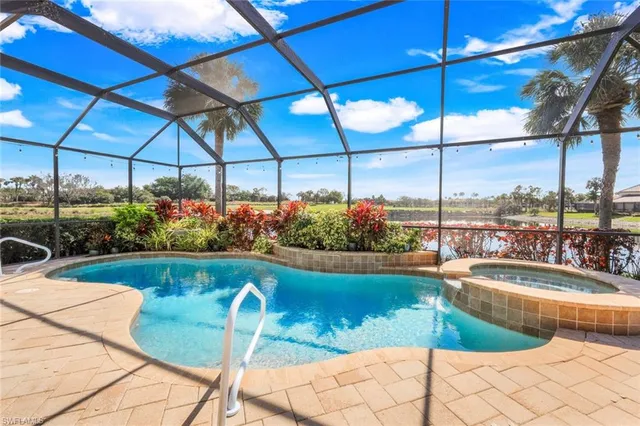 a view of a swimming pool with a lawn chairs under an umbrella