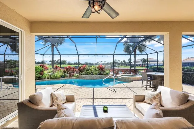a living room with furniture a chandelier and a floor to ceiling window
