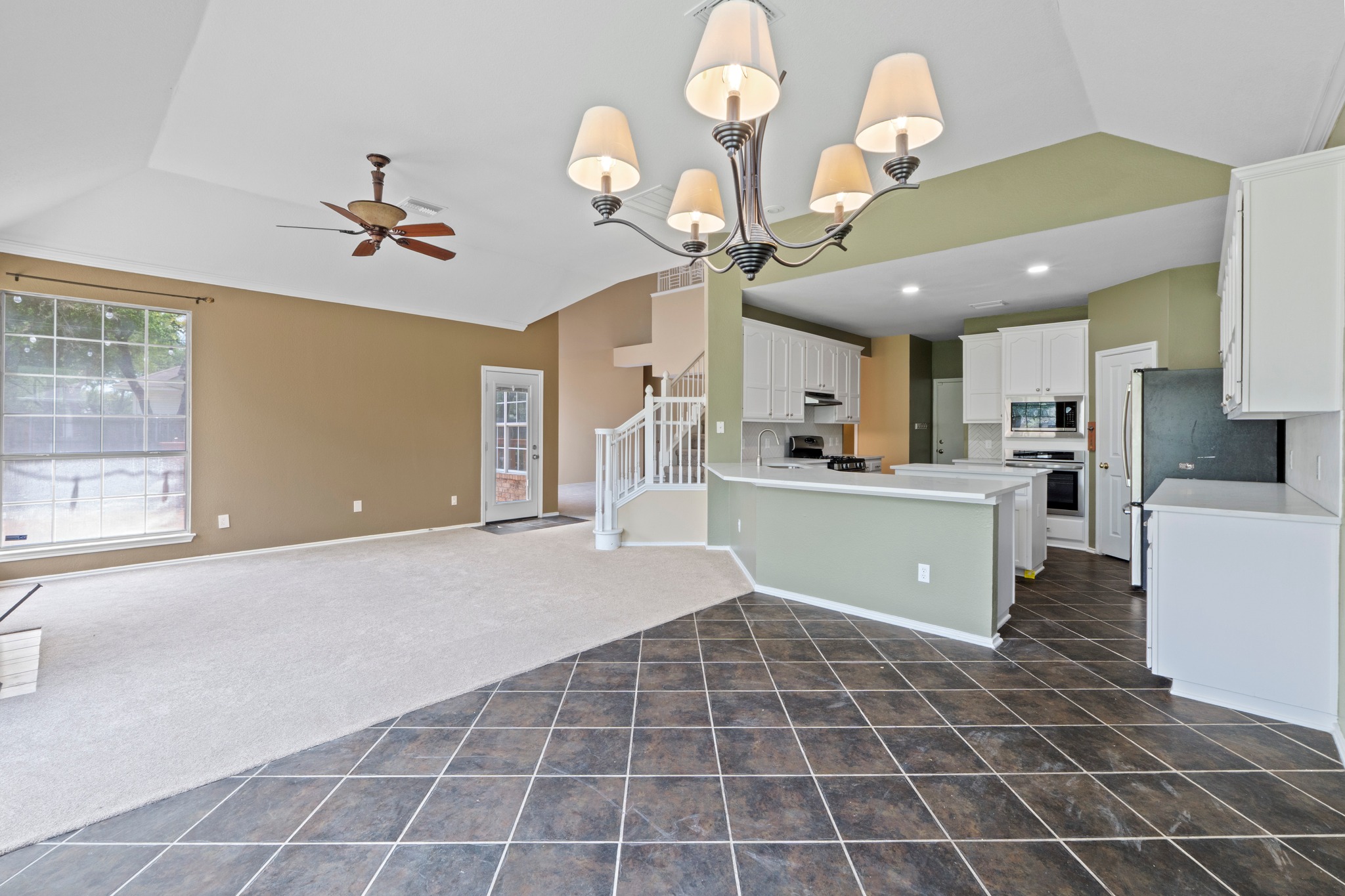 8605 Axis Drive Austin, TX 78749 - Photo 10 of 38 An open-concept living space integrates a well-appointed kitchen and a comfortable carpeted area, highlighted by soaring ceilings.