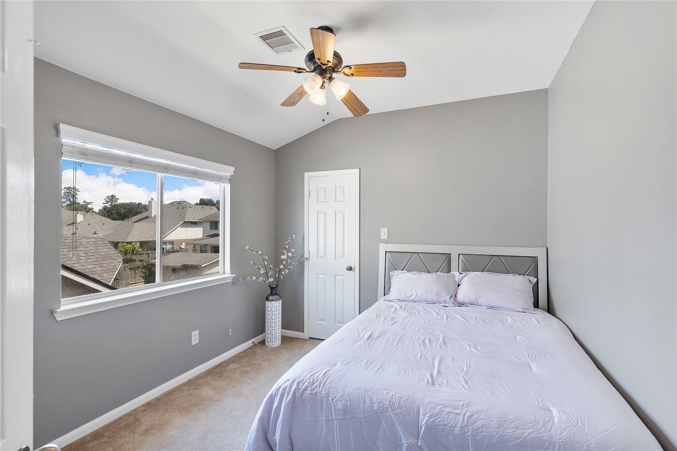 24506 Fort Path Drive Spring, TX 77373 - Photo 32 of 46 Cozy bedroom with soft gray walls, a ceiling fan, and a large window offering natural light and neighborhood views.