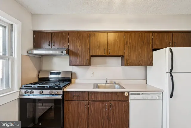 a kitchen with a stove a refrigerator and a sink