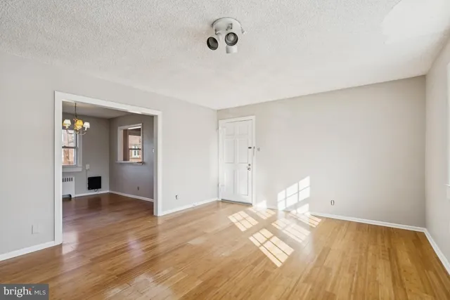 a view of empty room with wooden floor