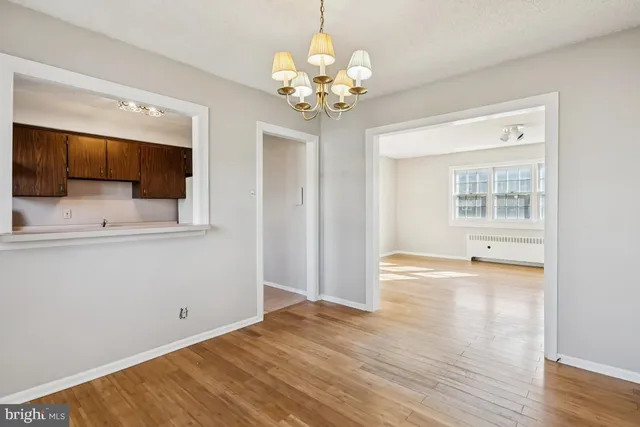a view of a room with wooden floor and chandelier