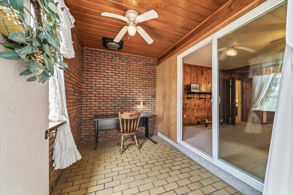 Sunroom featuring ceiling fan and a patio