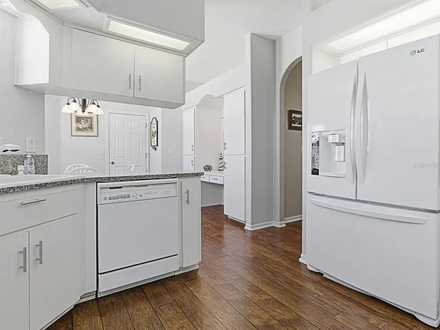 a kitchen with white cabinets and white appliances