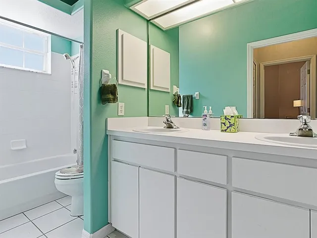 a bathroom with a double vanity sink toilet and shower