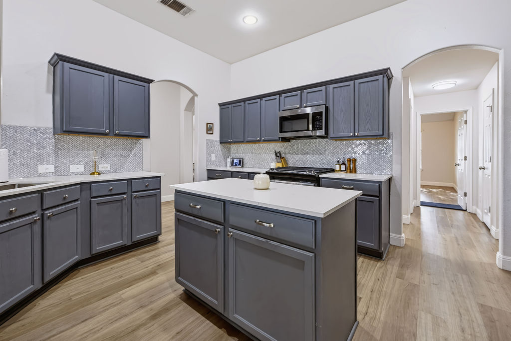 400 Ranier Lane Round Rock, TX 78665 - Photo 13 of 36 Richly toned cabinetry and stone counters anchor this kitchen accented by wood-textured floors.