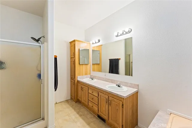 a bathroom with a double vanity sink mirror and shower