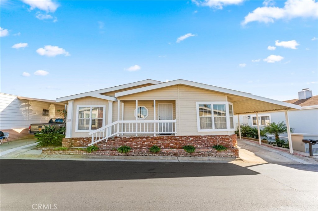 23301 Ridge Rte Drive, Unit 165 Laguna Hills, CA 92653 - Photo 2 of 31 a front view of a house with a garden