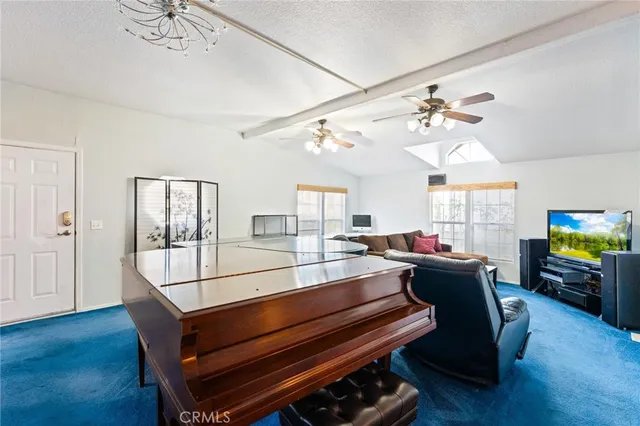 a living room with furniture a flat screen tv and a chandelier